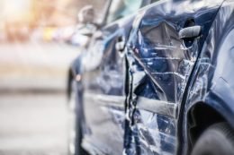 A blurred close-up of a wrecked blue car.