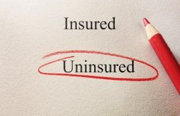The word “uninsured” circled with red pencil on textured paper